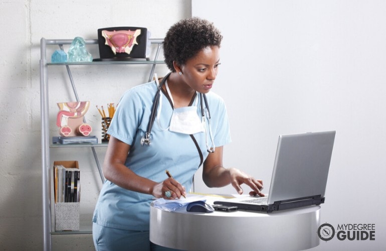 una enfermera estudiando en su computadora