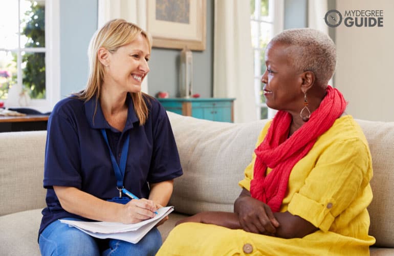 Trabajadora de salud comunitaria visitando a una anciana en su casa