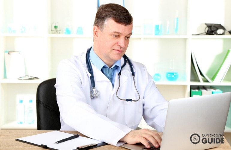 Administrador de salud trabajando en su computadora portátil en su oficina