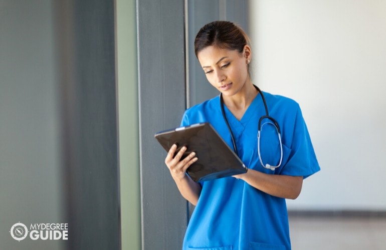 enfermera practicante mirando los datos del paciente en una tableta