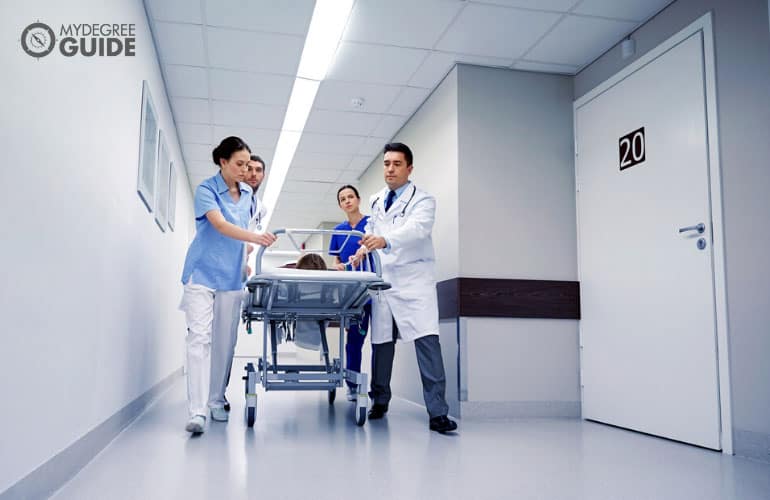 grupo de profesionales médicos que llevan a un paciente inconsciente a la sala de cirugía