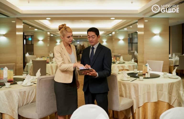 gerente de hotel hablando con un coordinador de eventos en un banquete