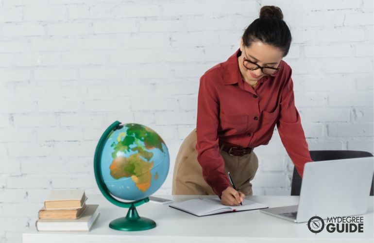 Mujer completando su maestría en línea en geografía