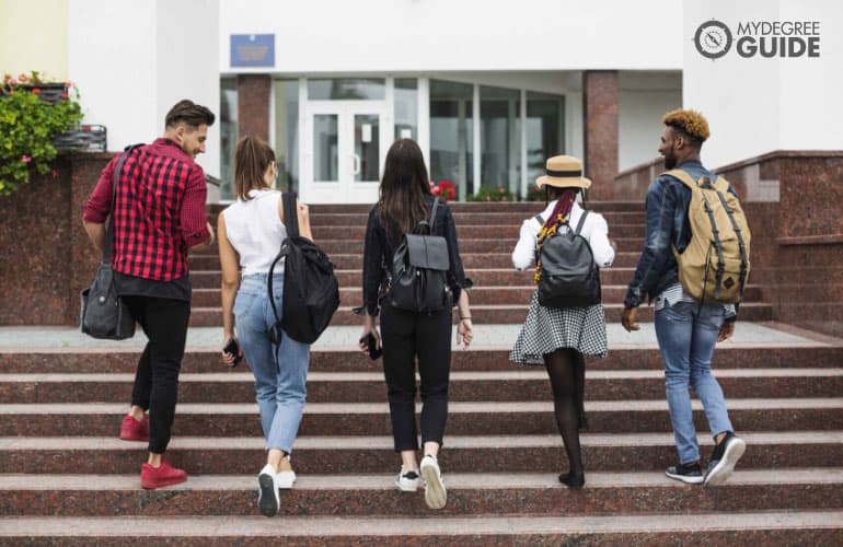 estudiantes caminando por un campus universitario