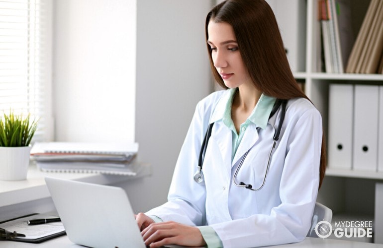 Técnico registrado en información de salud trabajando en su computadora portátil