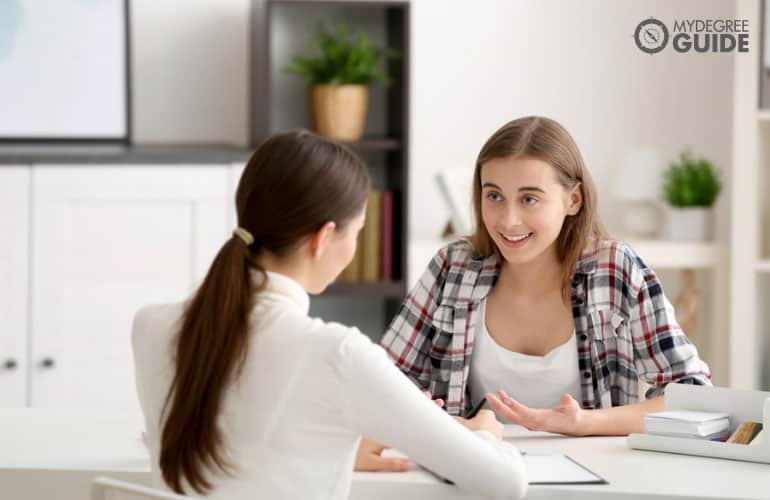 psicóloga hablando con una adolescente en su oficina