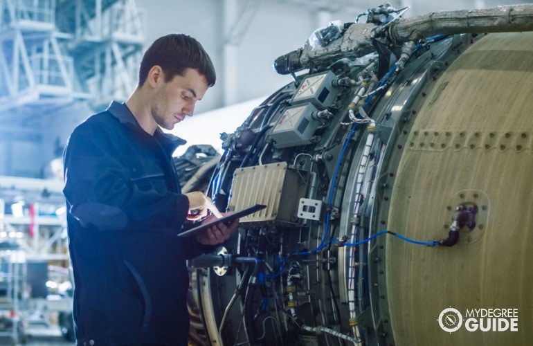 Ingeniero aeroespacial revisando el motor de un avión