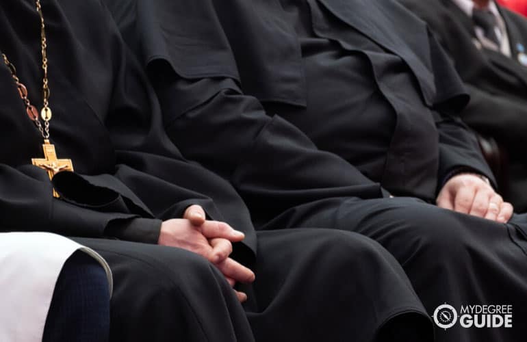 clero y sacerdotes sentados en una iglesia